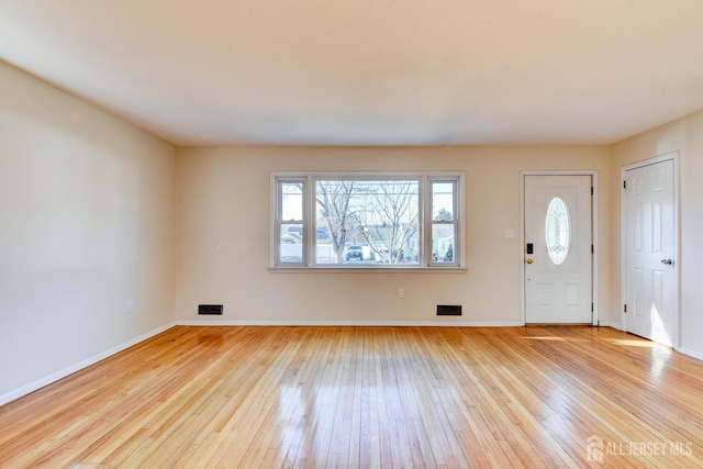 foyer featuring baseboards, visible vents, and hardwood / wood-style floors