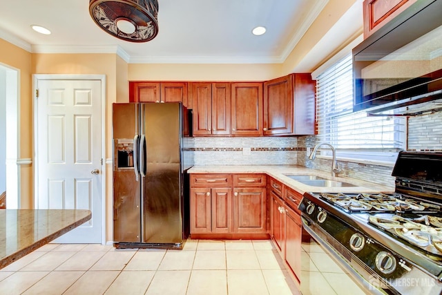 kitchen with light stone counters, range with gas cooktop, black refrigerator with ice dispenser, and a sink