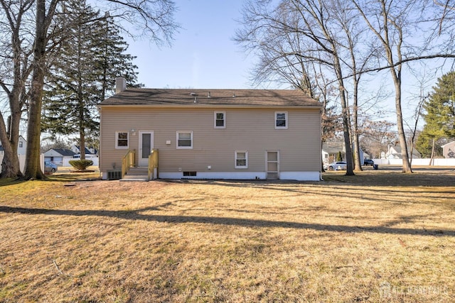 back of house with a yard, a chimney, and central AC unit