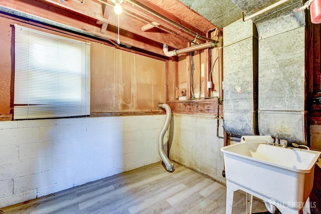 interior space featuring a sink, wood finished floors, and concrete block wall