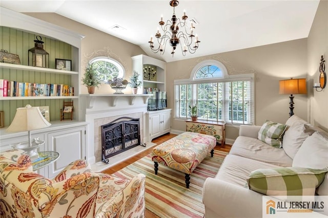 35 Parkview Rd, Cranbury, NJ 08512 - living room with vaulted ceiling, a chandelier, light wood finished floors, a fireplace with raised hearth, and built in shelves