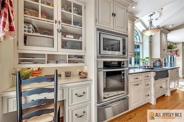 35 Parkview Rd, Cranbury, NJ 08512 - kitchen featuring appliances with stainless steel finishes, a warming drawer, light wood-style floors, and glass insert cabinets