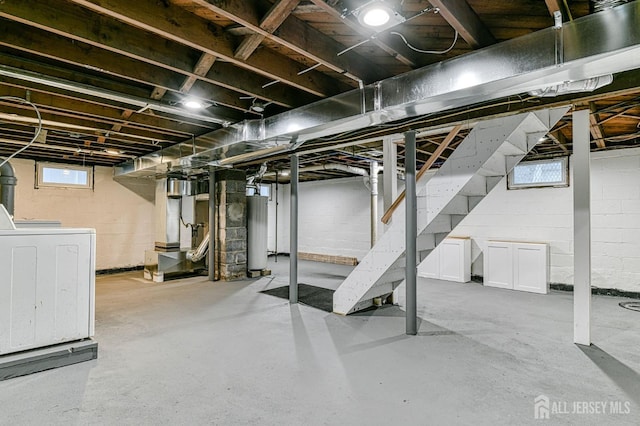 basement with washer / dryer, water heater, and stairs