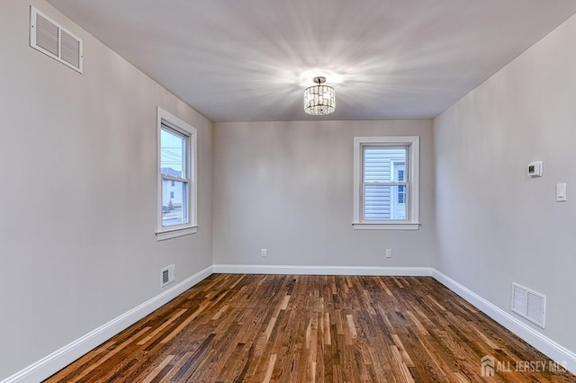 spare room featuring plenty of natural light, visible vents, and baseboards