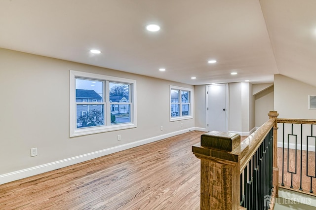 interior space with lofted ceiling, recessed lighting, an upstairs landing, light wood-type flooring, and baseboards