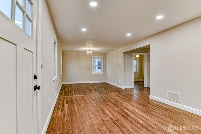 unfurnished room featuring baseboards, visible vents, wood finished floors, and recessed lighting