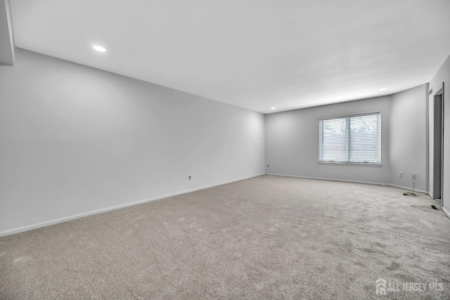 carpeted empty room featuring recessed lighting and baseboards