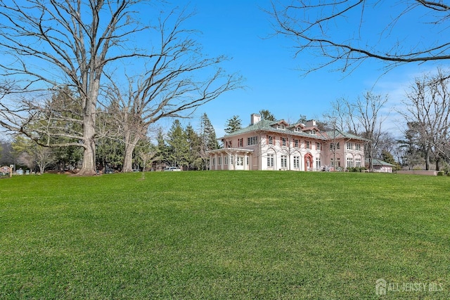 view of side of property with a lawn and a chimney