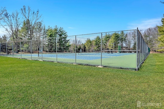 view of sport court featuring a lawn and fence