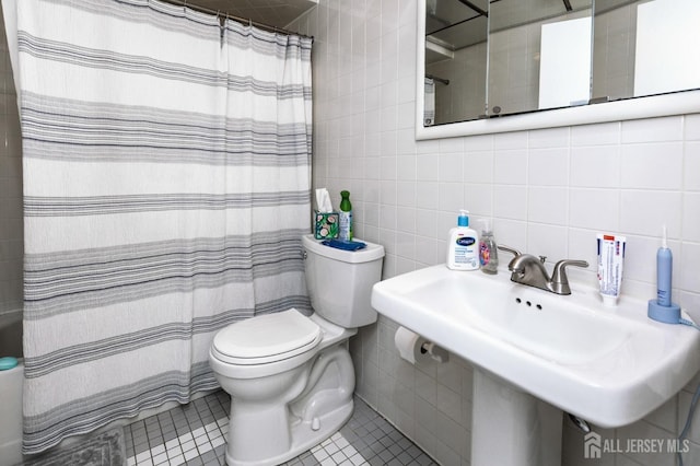 full bathroom featuring tile walls, backsplash, toilet, a sink, and tile patterned floors