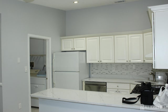 29 E Wycoff Way E, Brunswick, NJ 08816 - kitchen featuring freestanding refrigerator, dishwasher, independent washer and dryer, light stone counters, and decorative backsplash