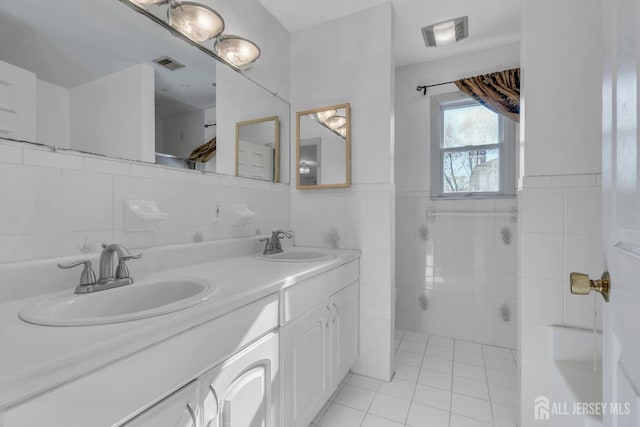 bathroom featuring vanity, tile patterned floors, and tile walls