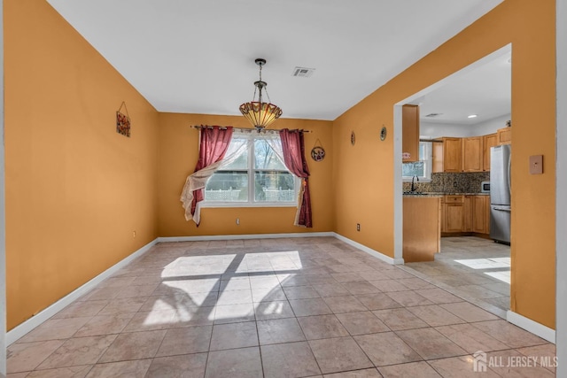 unfurnished dining area with sink and light tile patterned floors