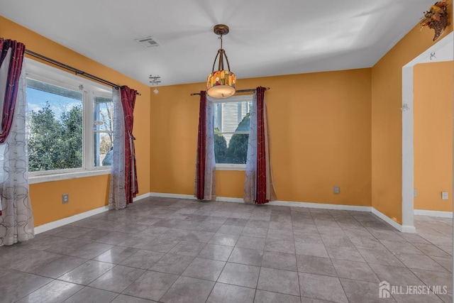 tiled empty room featuring plenty of natural light