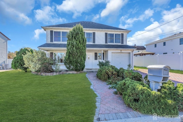 front of property featuring central AC unit, a garage, and a front yard