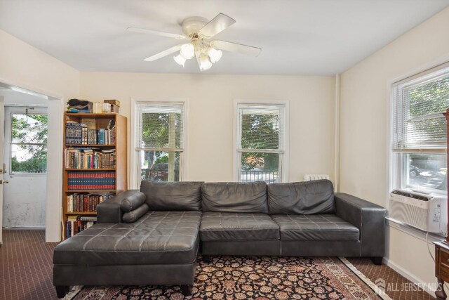 carpeted living room with ceiling fan and cooling unit