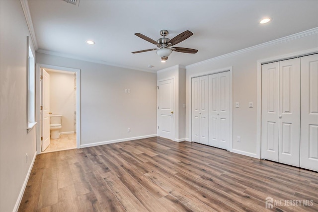 unfurnished bedroom featuring crown molding, ceiling fan, ensuite bathroom, and wood-type flooring