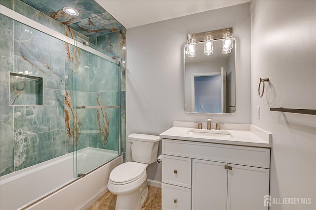 full bathroom with vanity, combined bath / shower with glass door, and toilet