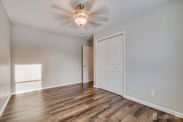 unfurnished bedroom with dark hardwood / wood-style floors, a closet, and ceiling fan