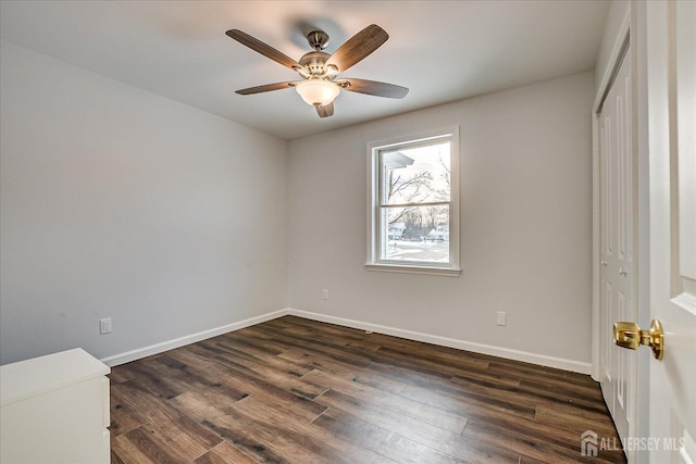 empty room featuring ceiling fan and dark hardwood / wood-style flooring