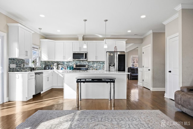 783 Aborn Ave, Woodbridge Proper, NJ 07095 - kitchen with appliances with stainless steel finishes, a kitchen island, tasteful backsplash, dark wood-type flooring, and crown molding