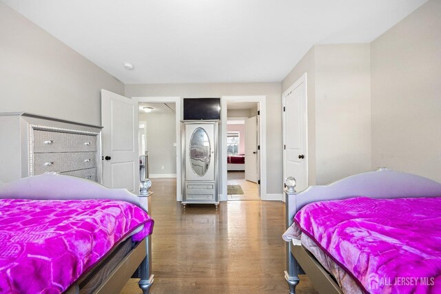bedroom featuring wood finished floors and baseboards