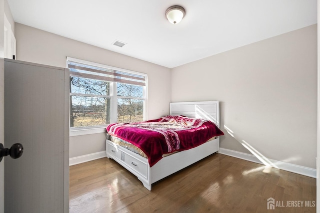 bedroom featuring wood finished floors and baseboards