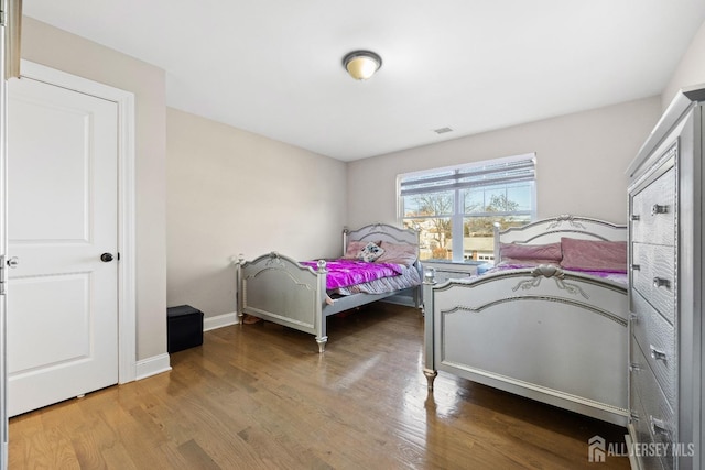 bedroom with wood finished floors and baseboards