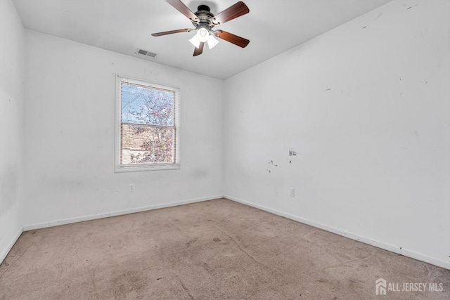 spare room with ceiling fan and light carpet