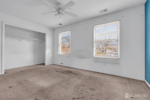 unfurnished bedroom with ceiling fan, light colored carpet, and a closet