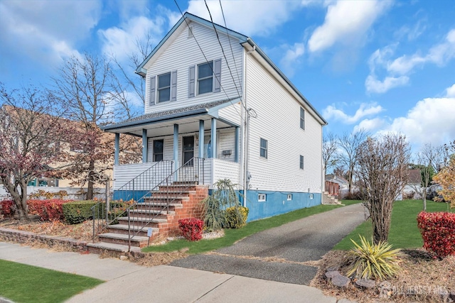 view of front of house featuring covered porch and a front yard