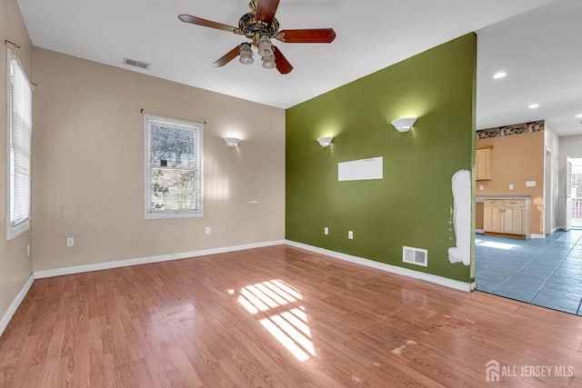 unfurnished room featuring ceiling fan, a healthy amount of sunlight, and light wood-type flooring