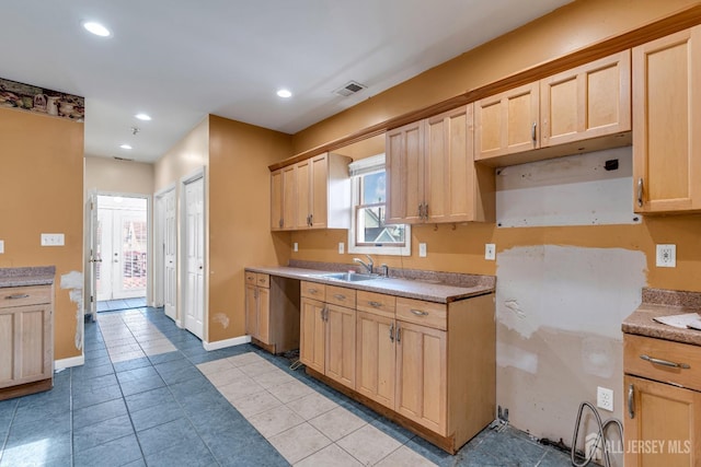 kitchen featuring light tile patterned floors, light brown cabinetry, and sink