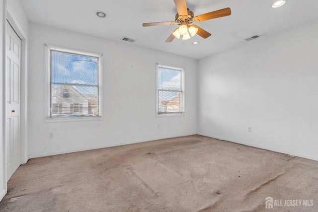 carpeted spare room with ceiling fan