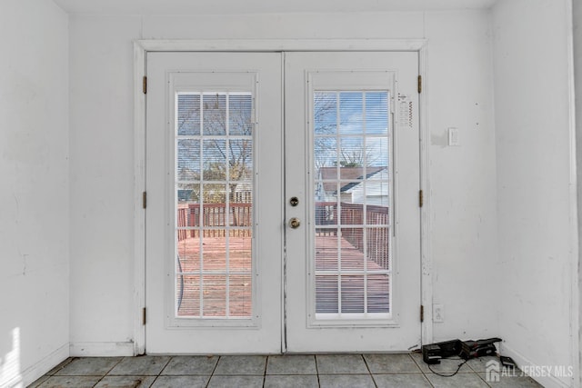 doorway to outside featuring a wealth of natural light, french doors, and light tile patterned floors