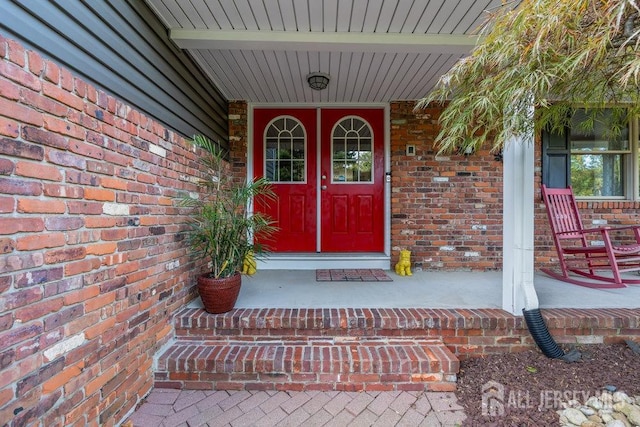 view of exterior entry featuring covered porch