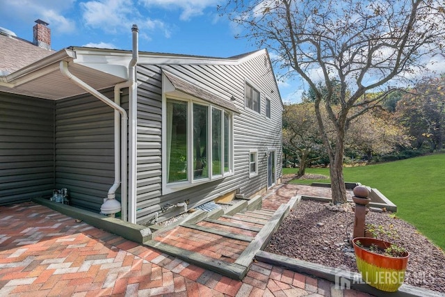 view of home's exterior with a yard and a patio