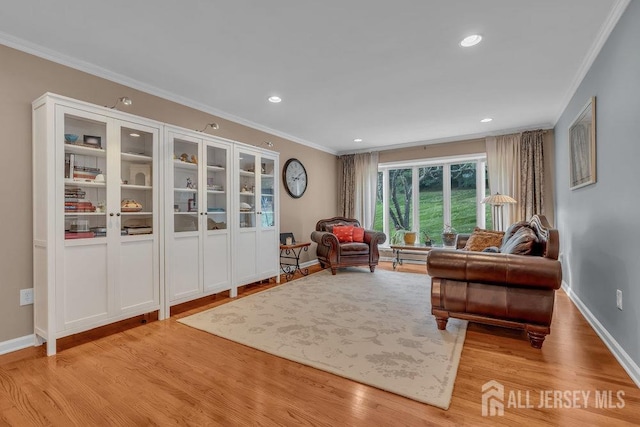 sitting room with crown molding and light hardwood / wood-style flooring