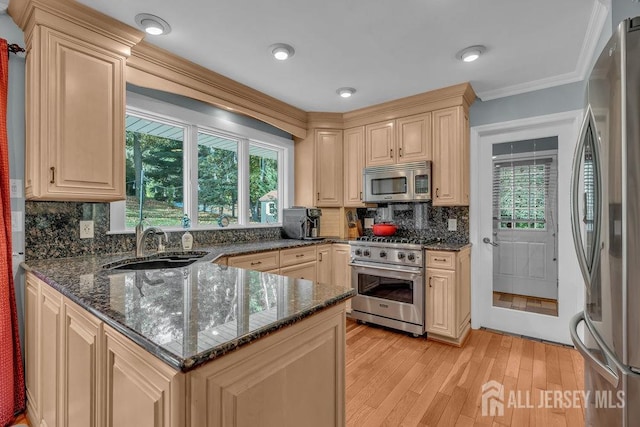 kitchen featuring stainless steel appliances, dark stone counters, crown molding, light hardwood / wood-style floors, and tasteful backsplash