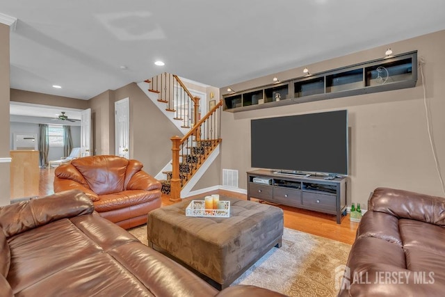 living room featuring light wood-type flooring and ceiling fan