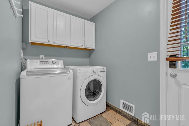 washroom featuring washer and dryer and cabinets