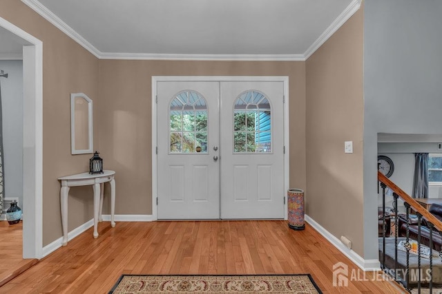 entrance foyer featuring crown molding, light hardwood / wood-style flooring, and french doors