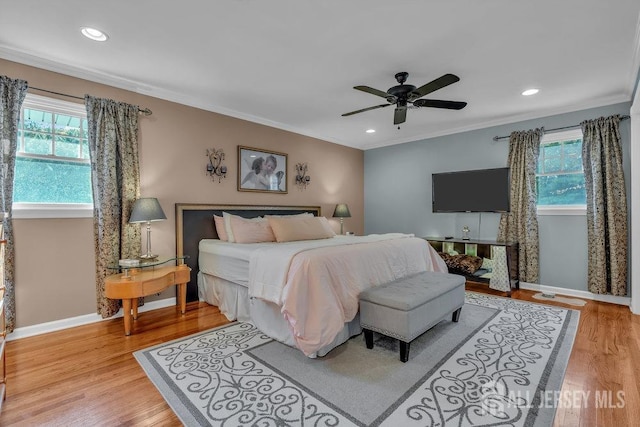 bedroom featuring crown molding, light wood-type flooring, and ceiling fan