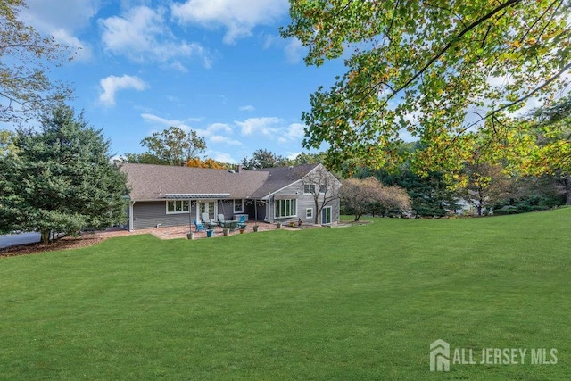 back of house featuring a patio and a yard