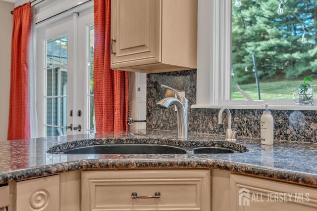 kitchen with a healthy amount of sunlight, sink, light brown cabinetry, and backsplash