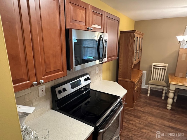 9 Maine Ct, Old Bridge, NJ 07747 - kitchen featuring stainless steel appliances, light countertops, dark wood-style flooring, backsplash, and brown cabinets