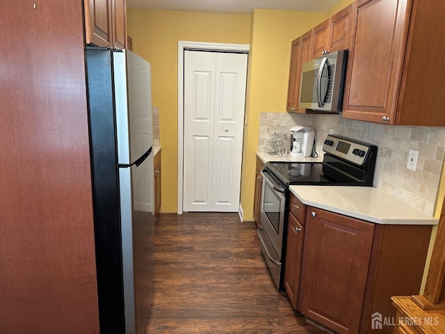 9 Maine Ct, Old Bridge, NJ 07747 - kitchen featuring stainless steel appliances, dark wood-style flooring, light countertops, decorative backsplash, and brown cabinetry