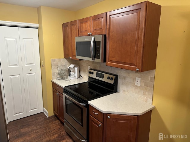 9 Maine Ct, Old Bridge, NJ 07747 - kitchen featuring stainless steel appliances, light countertops, dark wood-style flooring, and decorative backsplash