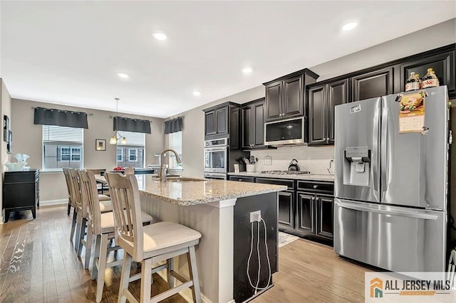 1501 Hights Farm Rd Unit 1501, Monroe, NJ 08831 - kitchen featuring appliances with stainless steel finishes, a sink, an island with sink, light wood-style floors, and recessed lighting