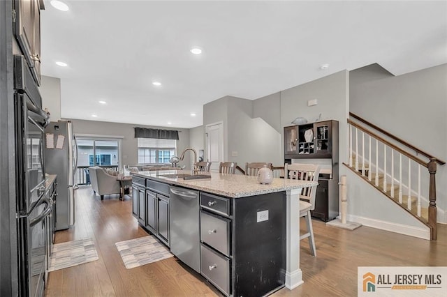 1501 Hights Farm Rd Unit 1501, Monroe, NJ 08831 - kitchen featuring stainless steel appliances, a sink, a kitchen breakfast bar, open floor plan, and wood finished floors